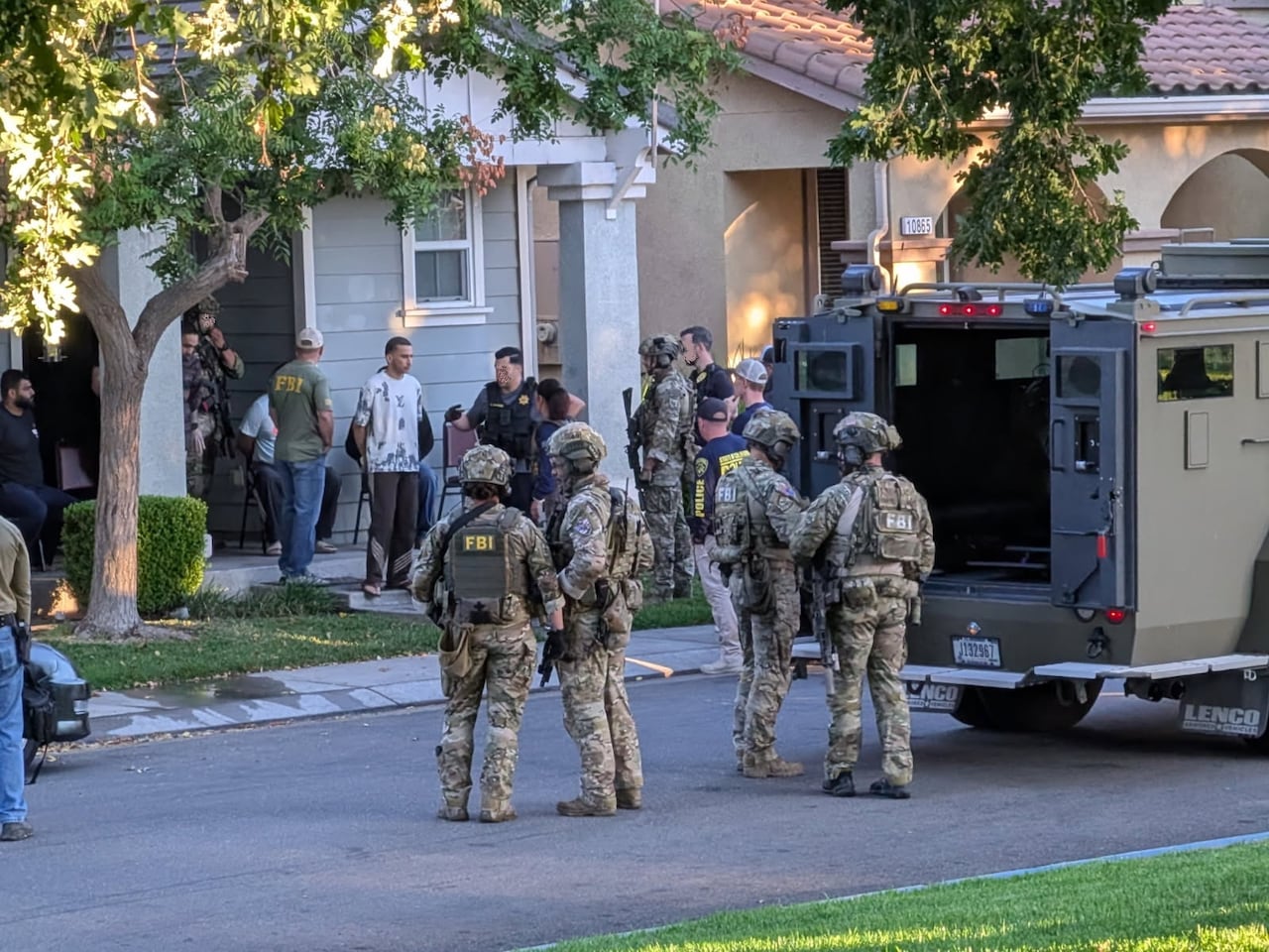 Officers in camouflage outside a house