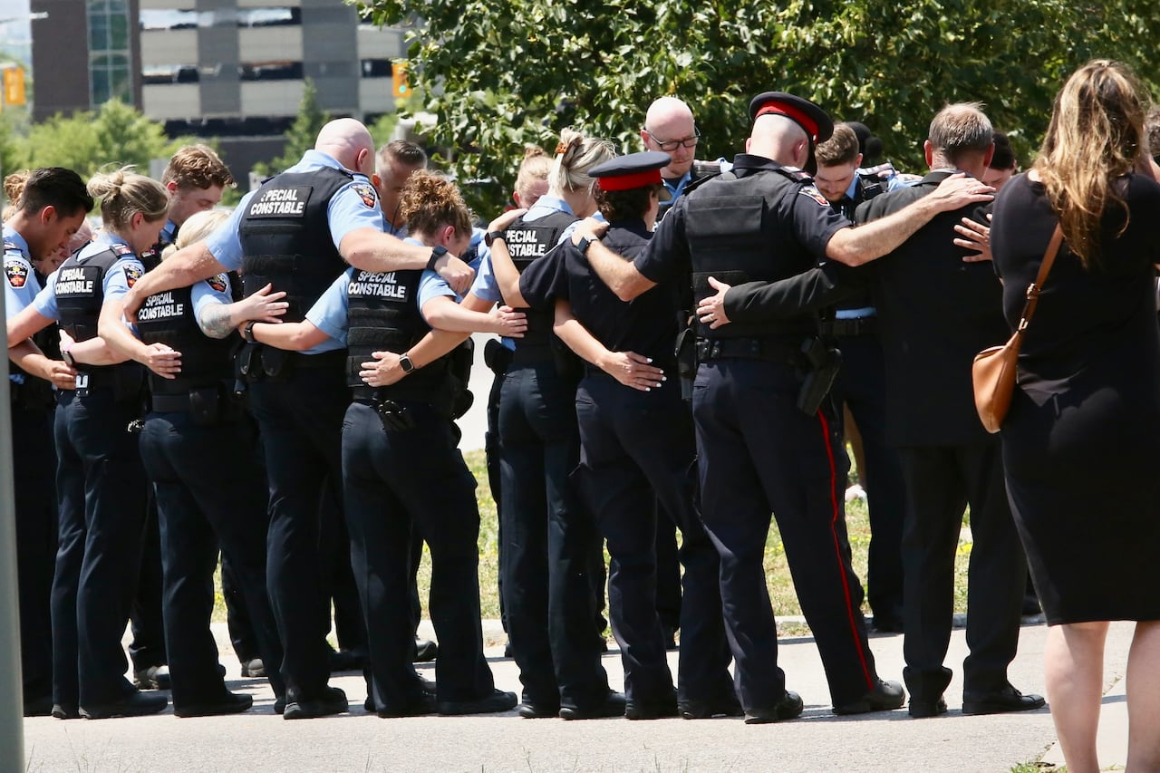 Durham police officers stand side by side during a funeral procession for a constable in training.