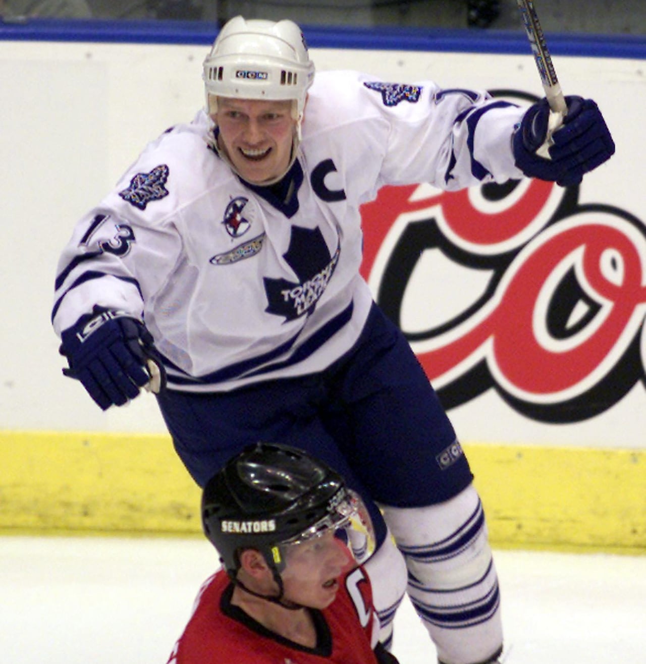 A hockey player celebrates a goal near a disappointed opponent.