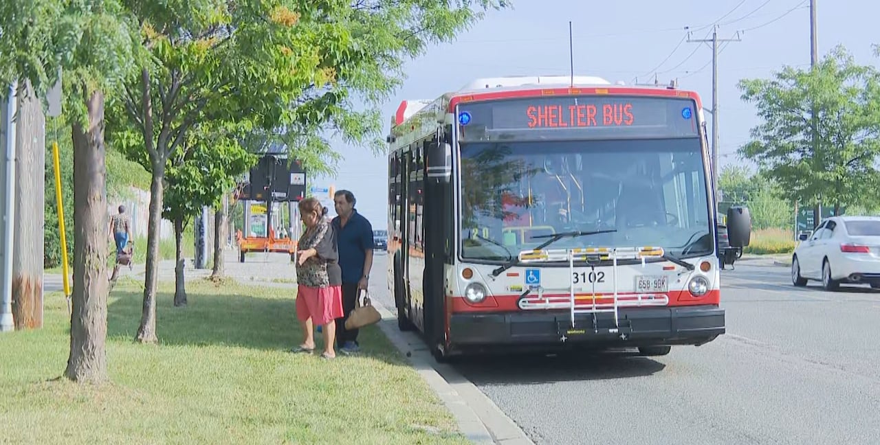 Two people walk of a TTC shelter bus