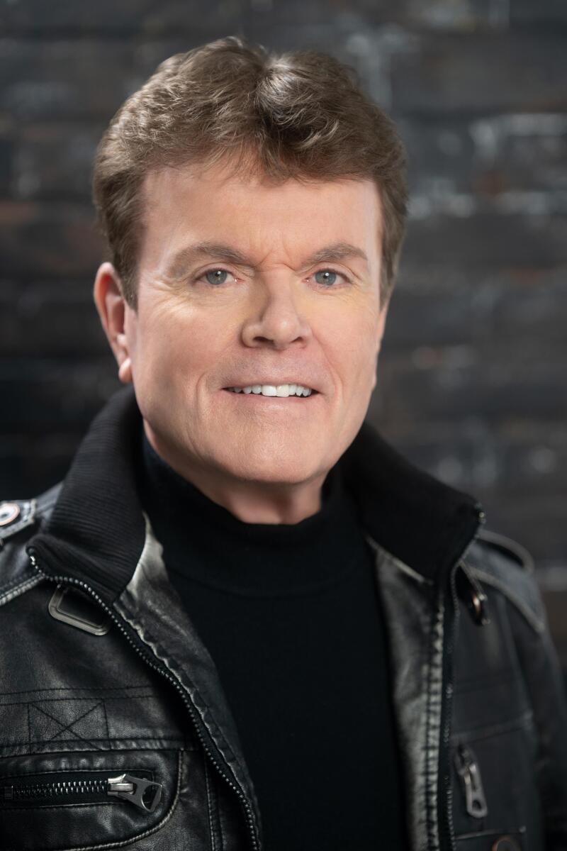 A man in a black leather jacket and black T-shirt.