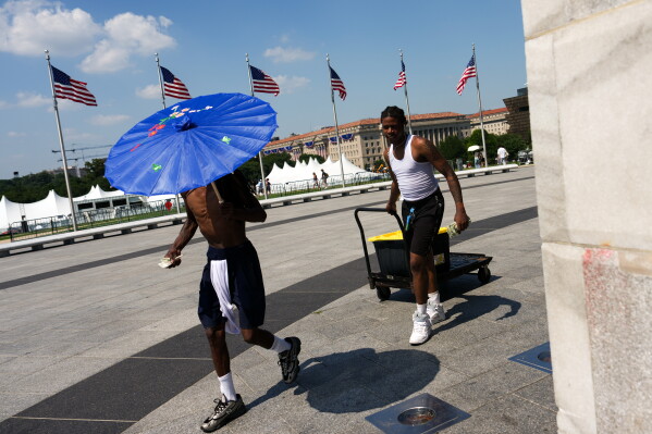 Vendors sell Gatorade and water bottles near the Washington Monument during a heat wave, July 3, 2026, in Washington. (AP Photo/Julia Demaree Nikhinson, File)