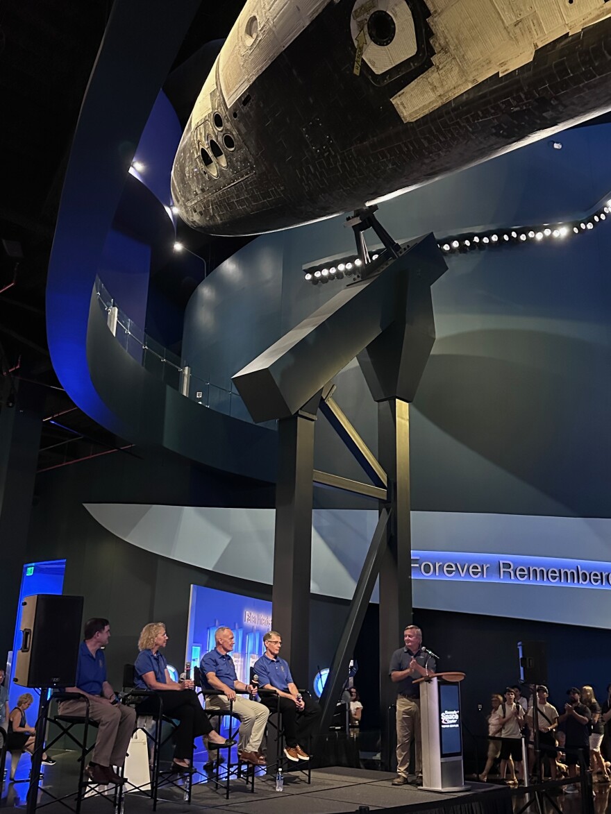 The STS-135 crew answered questions from former NASA Launch Director Mike Leinbach beneath the Atlantis display at the Kennedy Space Center Visitor Complex.