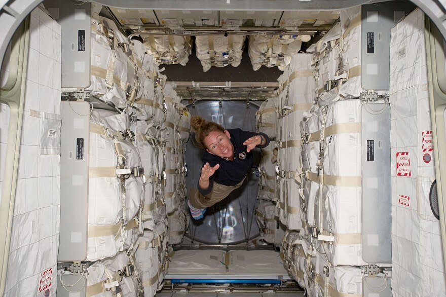 STS-135 mission specialist Sandy Magnus floats through a module packed with supplies for the International Space Station in this file photo from July 2011.