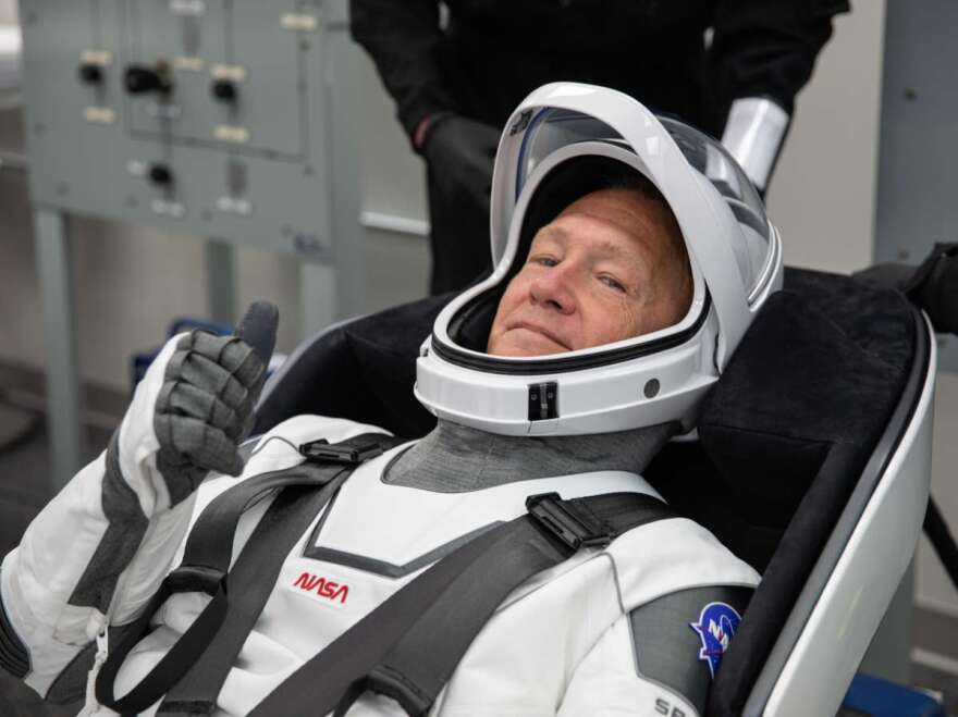 NASA astronaut Douglas Hurley rehearses putting on his SpaceX spacesuit at the Neil A. Armstrong Operations and Checkout Building Kennedy Space Center in Florida ahead of the DM-2 mission.
