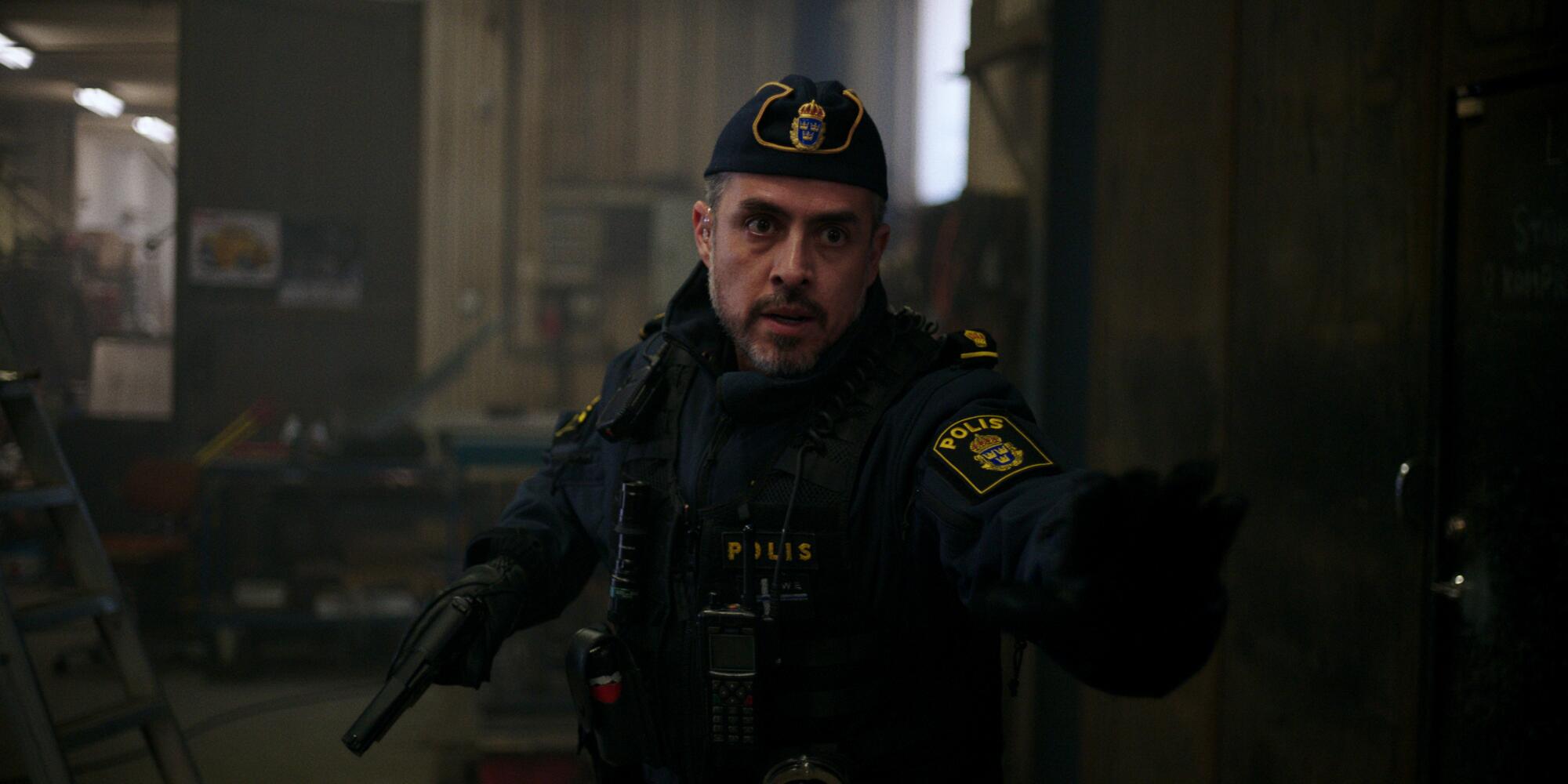 A police officer wields a gun in a scene from "The Åre Murders."