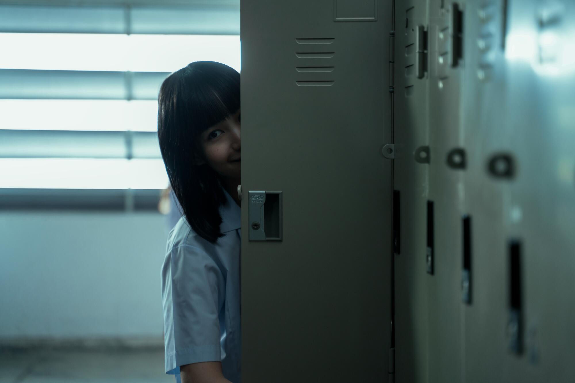 A schoolgirl stands behind a locker in "Girl From Nowhere."