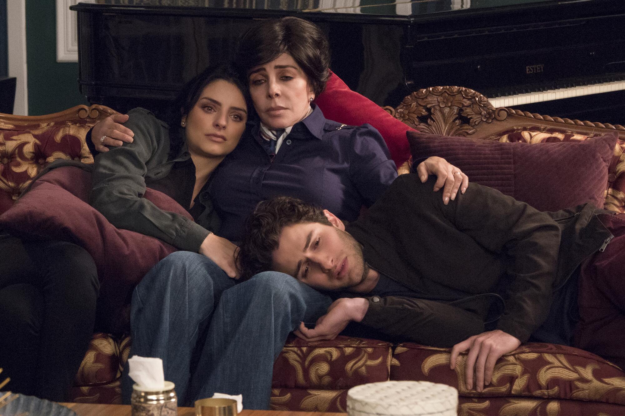Three family members on a couch in "The House of Flowers." 