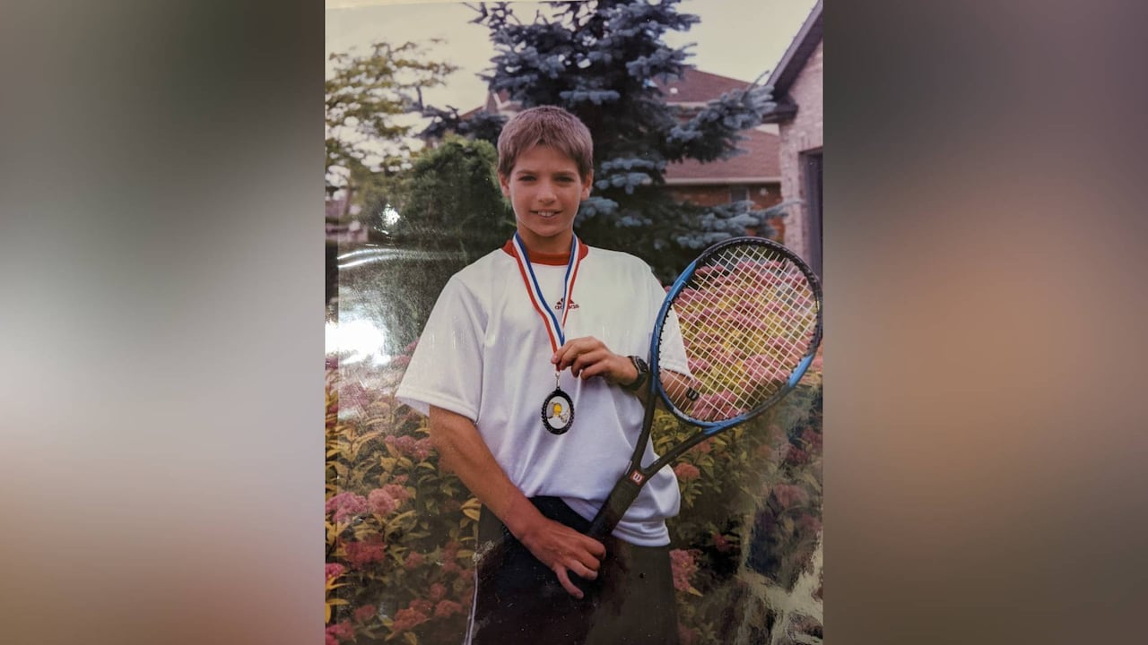An undated photo of Justin Bourassa holding a tennis racket