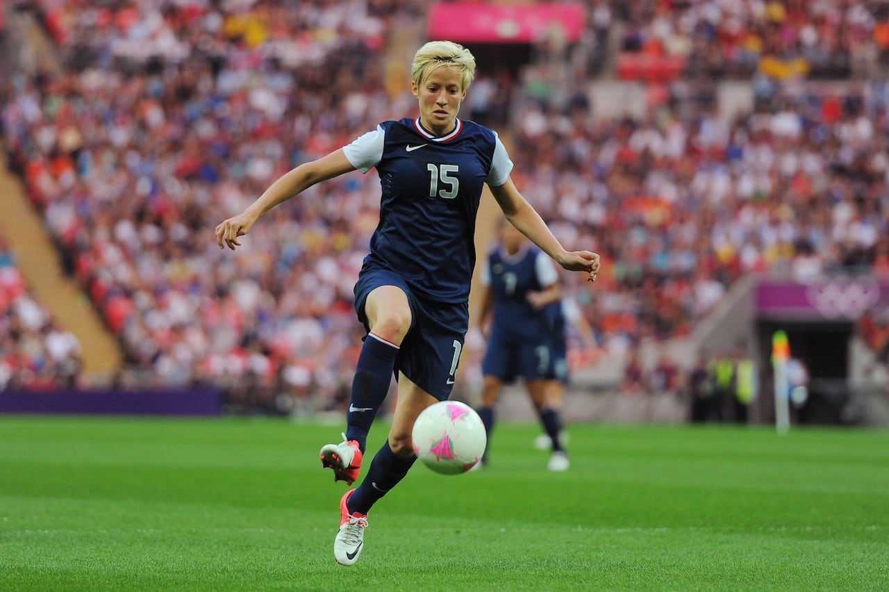 A woman in a #15 jersey kicks a soccer ball
