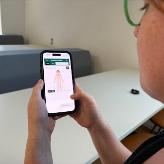 Girl with phone in hand open to symptom checker app.