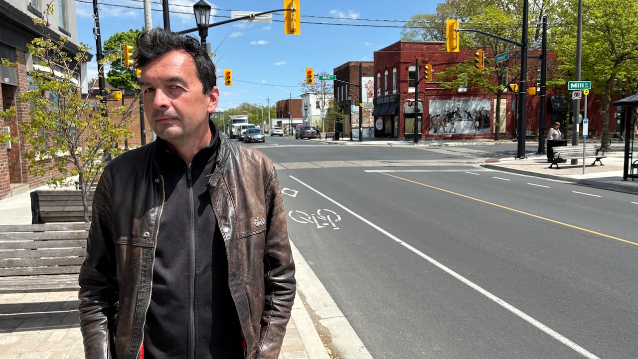 A man is standing in front of a road.