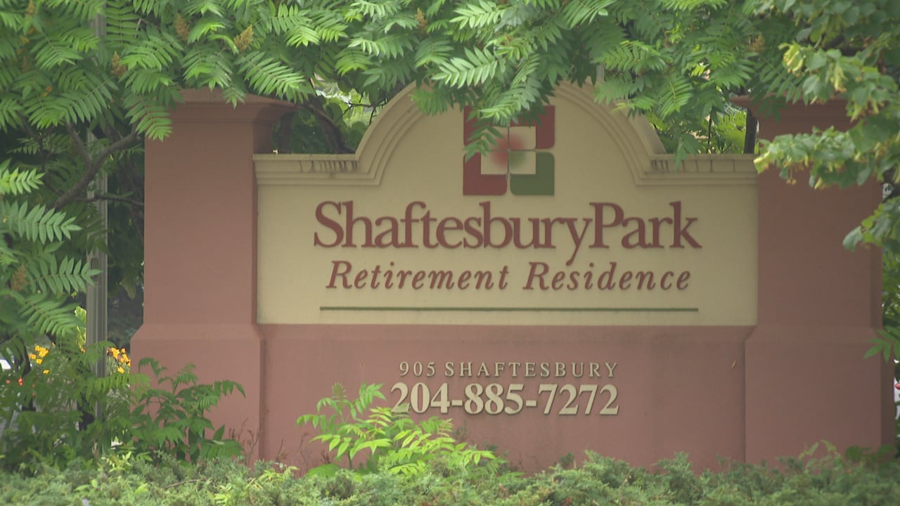 A building sign is in between the trees.
