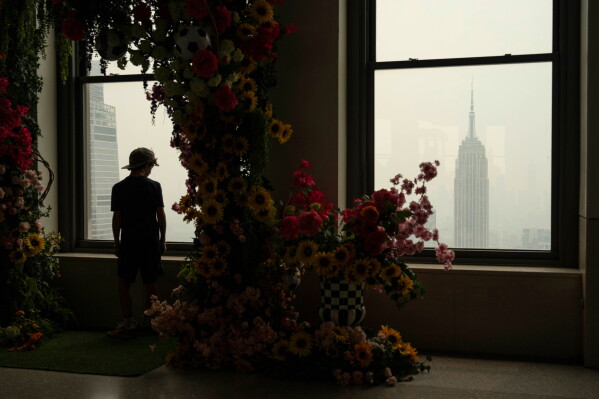 A person looks out a window at the Top of the Rock Observation Deck as wildfire smoke hangs over New York, Thursday, July 16, 2026. (AP Photo/Yuki Iwamura)