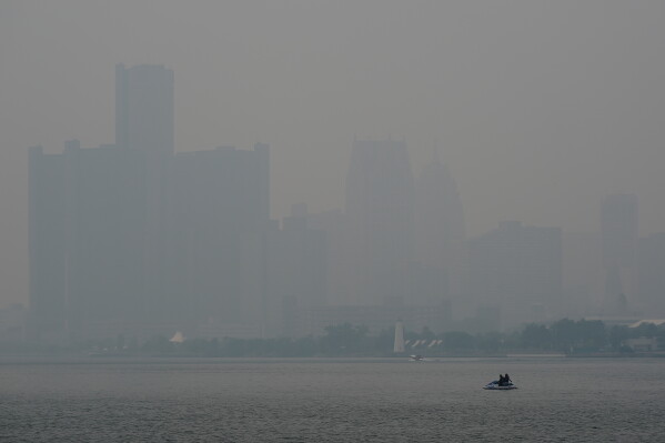 A watercraft sits in the Detroit River near the skyline during poor air quality due to smoke from Canadian wildfires Thursday, July 16, 2026, in Detroit. (AP Photo/Paul Sancya)