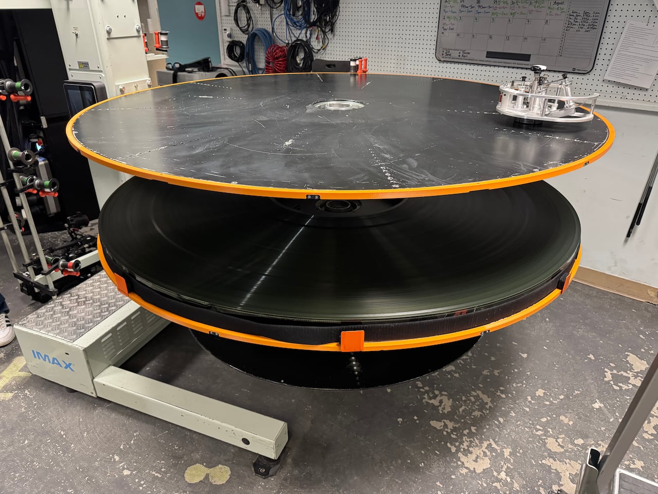 Huge, round film reel on a disk shaped platter.