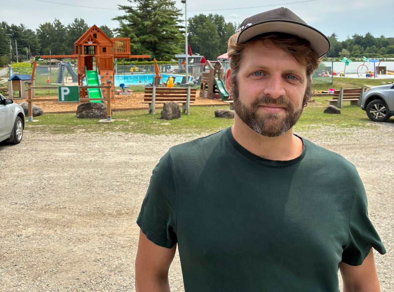 Photo of Philip Fortin, who stands in his campsite, Canne de bois
