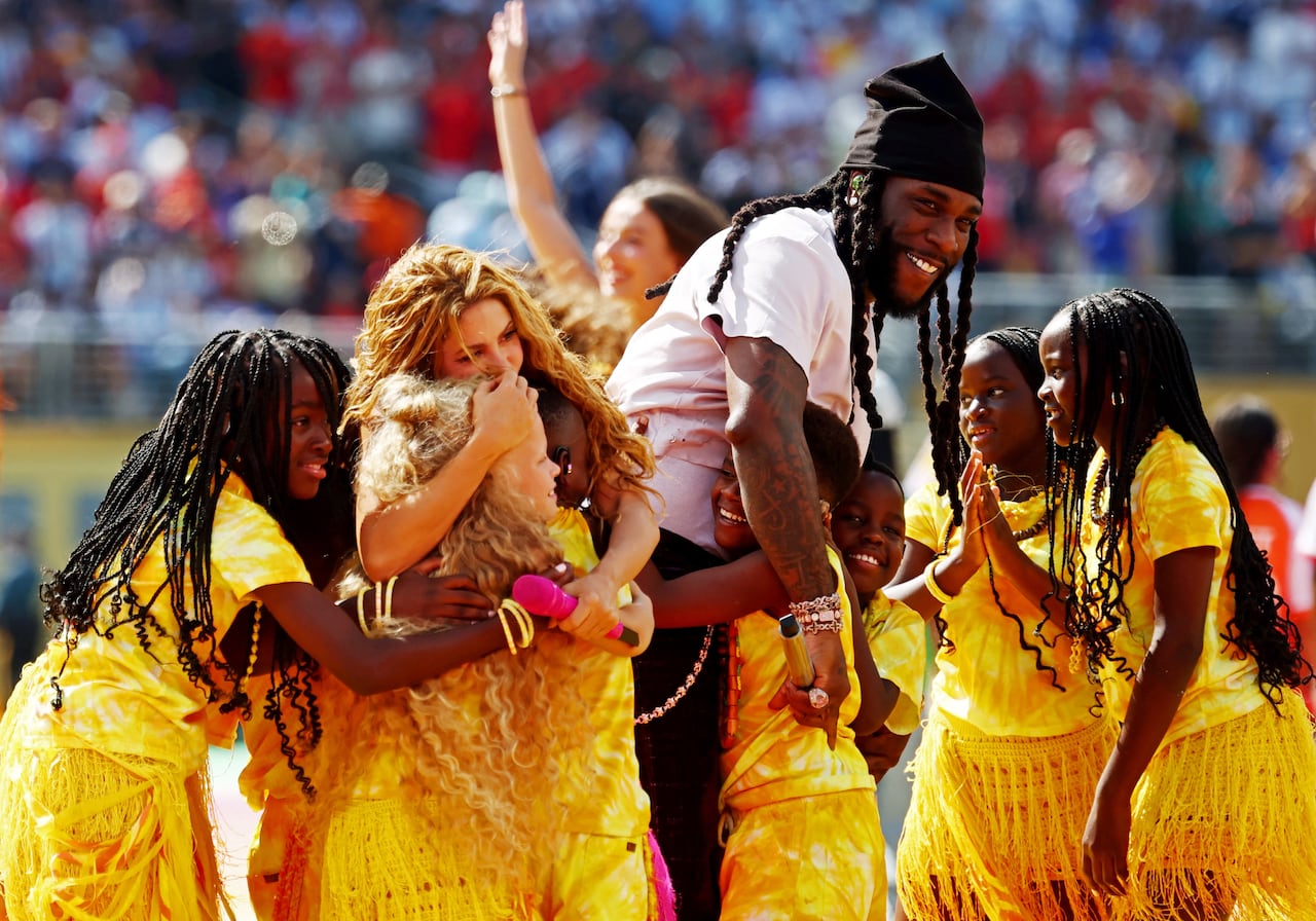 People smile and hug during a stadium performance