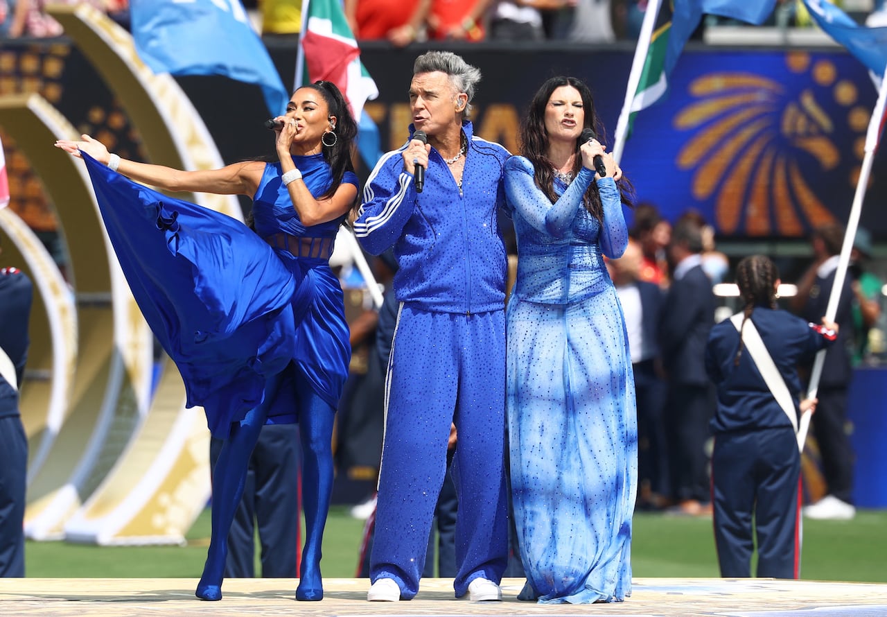 A man and two women, dressed in blue, sing