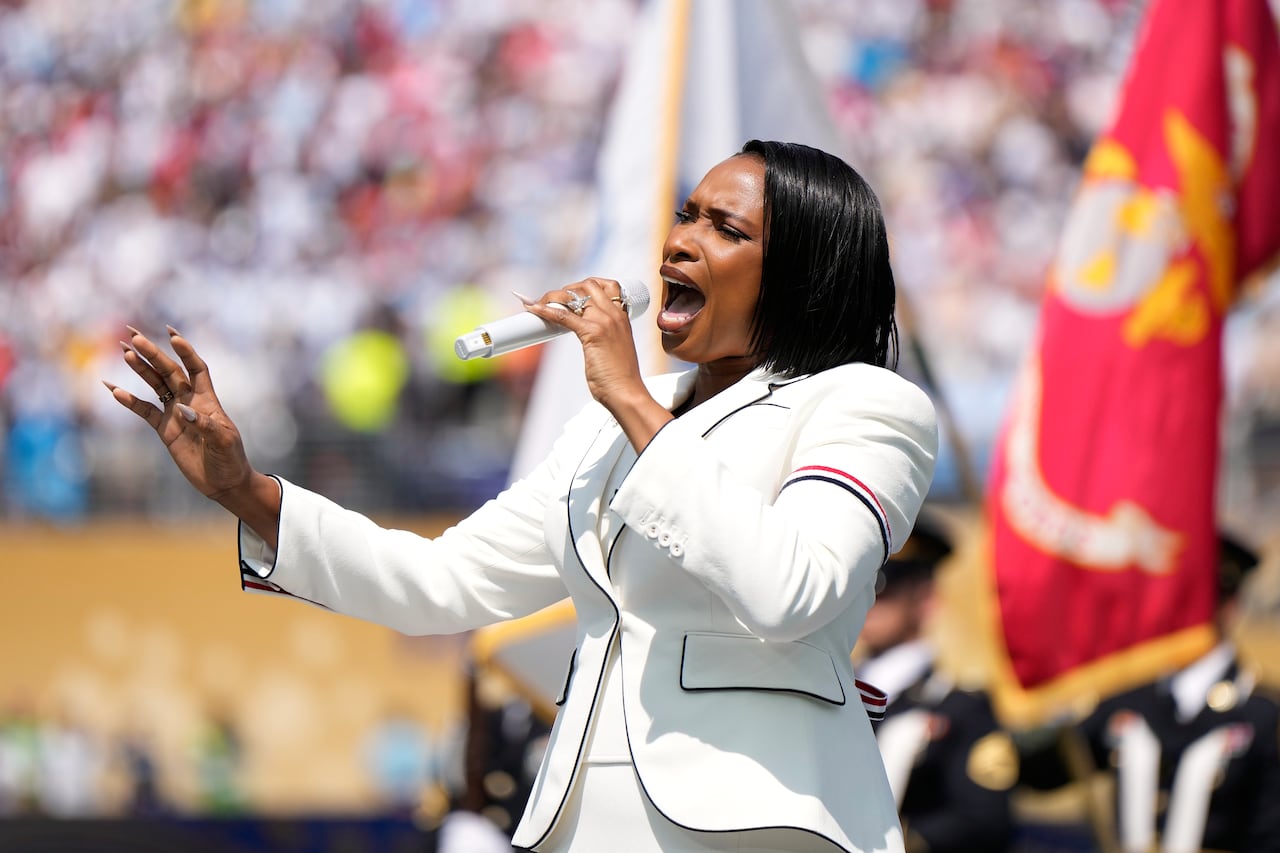 A woman sings in front of a crowd