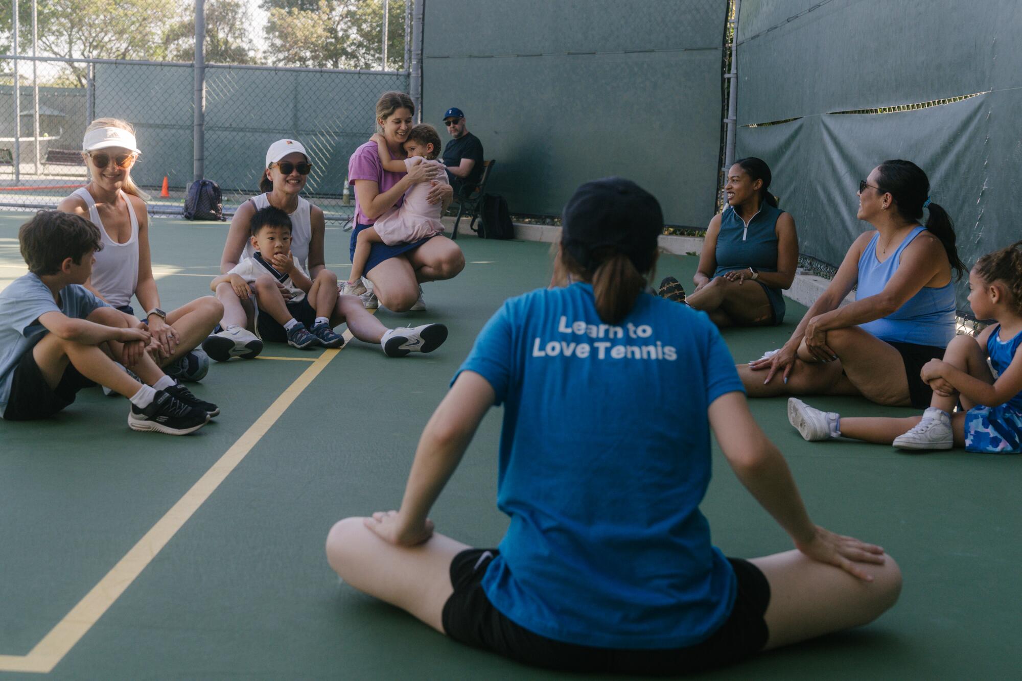 Coach Chessa Melman leads stretches with mothers and their children before class.