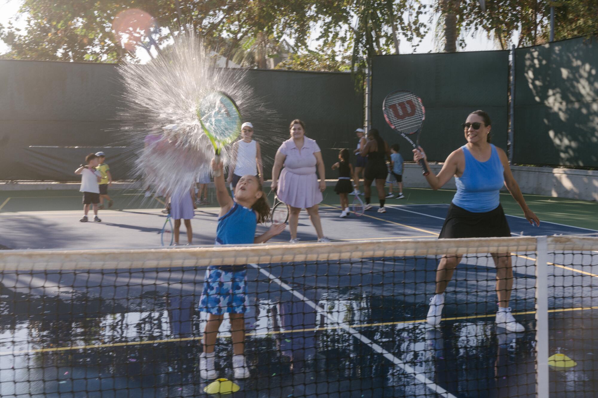 Jacqueline Castro watches as her daughter, Ruby, 5, hits a water balloon.