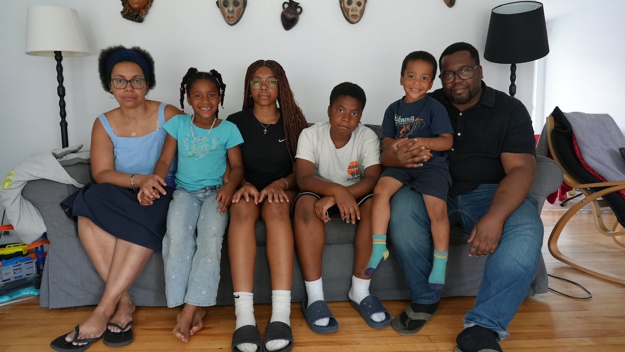 A family sitting on a couch, smiling