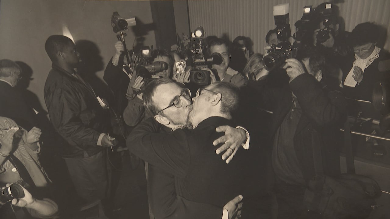 two men kissing after being married