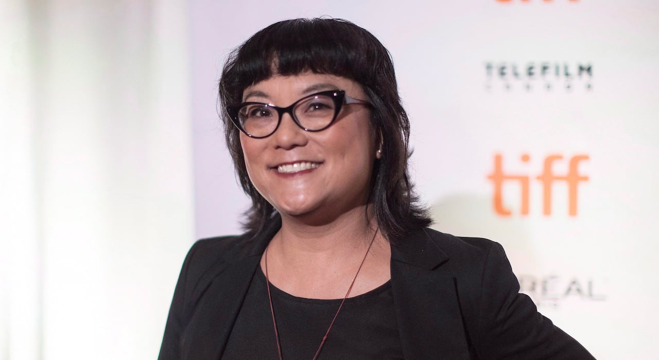 Woman with glasses smiles for the camera.