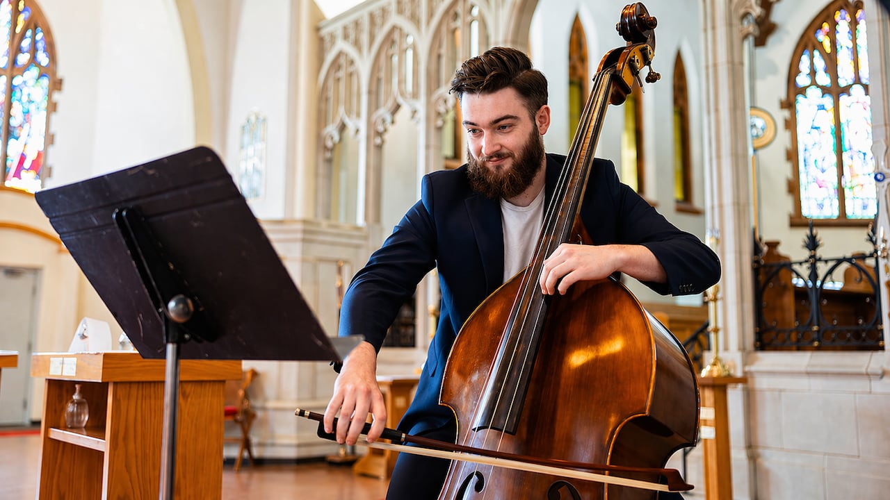 Cameron Breiter is pictured playing his double bass in a church.