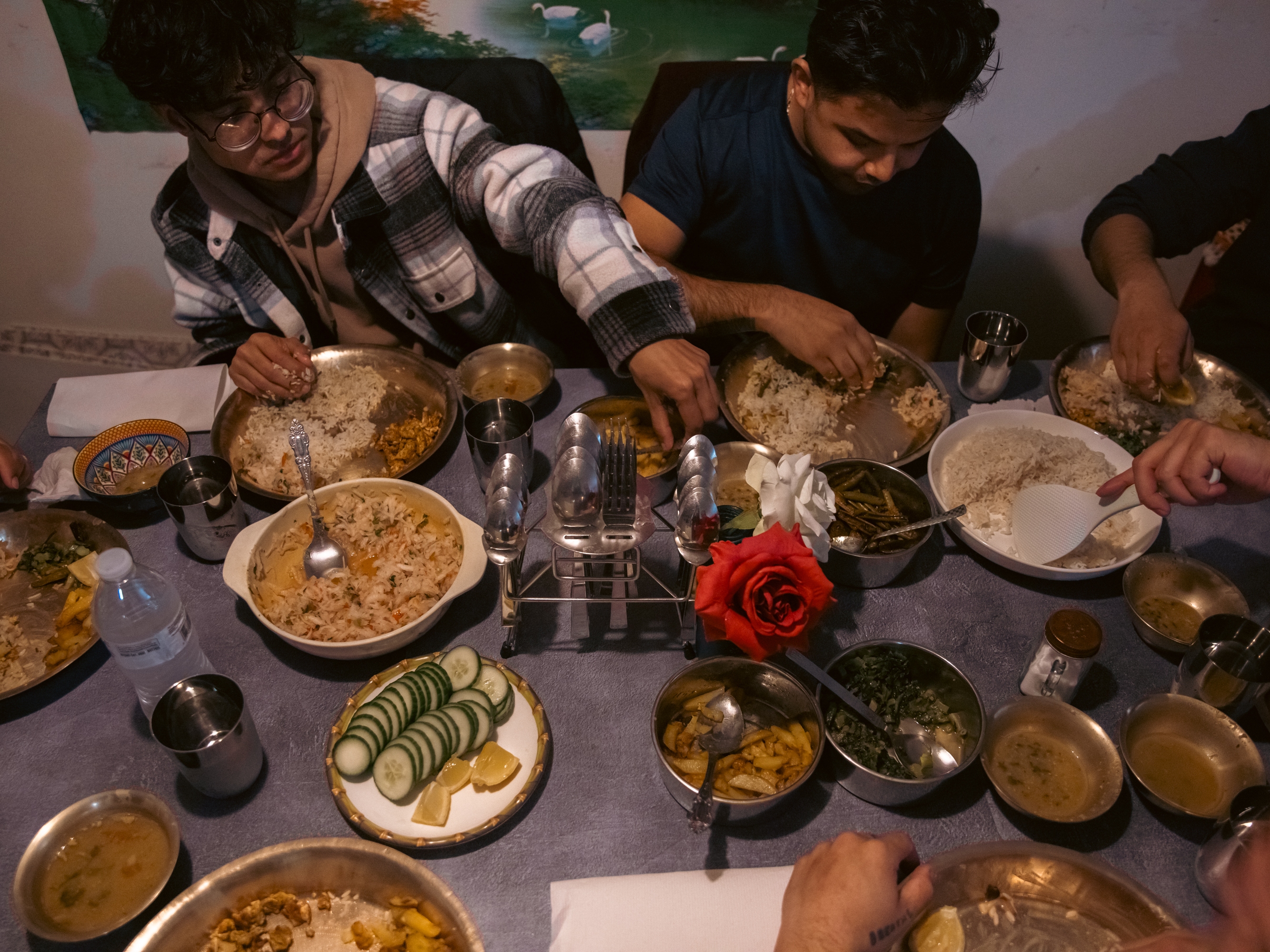 Bhagawat Dulal and Pratik Chhetri, staff members at ARU, eat together with community members and friends after soccer practice in Harrisburg, Pa., on April 16, 2025.