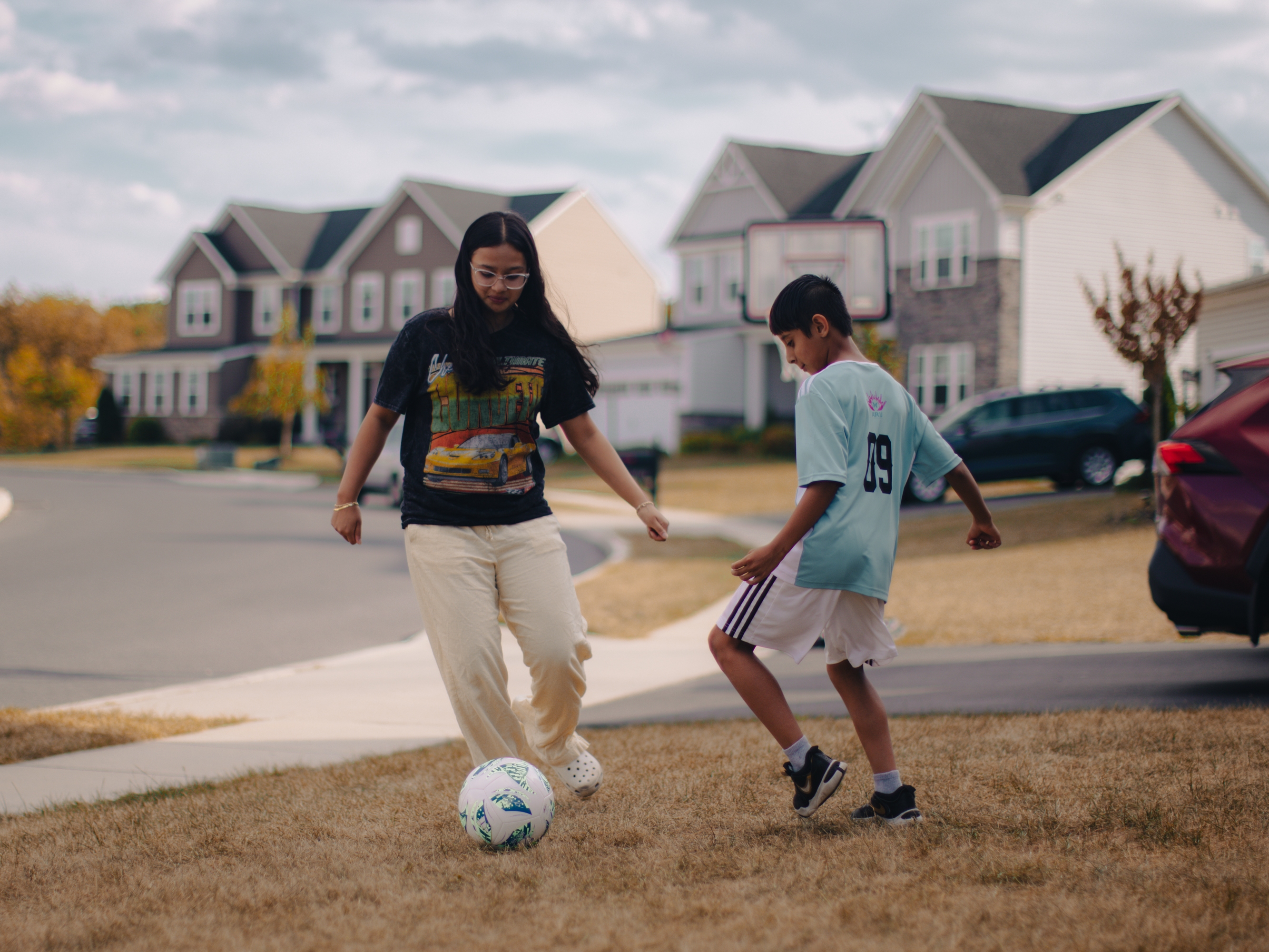 Kripal Khatiwoda, 10, plays soccer with his sister, Christina Khatiwoda, 14, in their front yard in Harrisburg, Pa., on Sept. 14, 2025. Kripal participates in ARU's Soccer for Success program.
