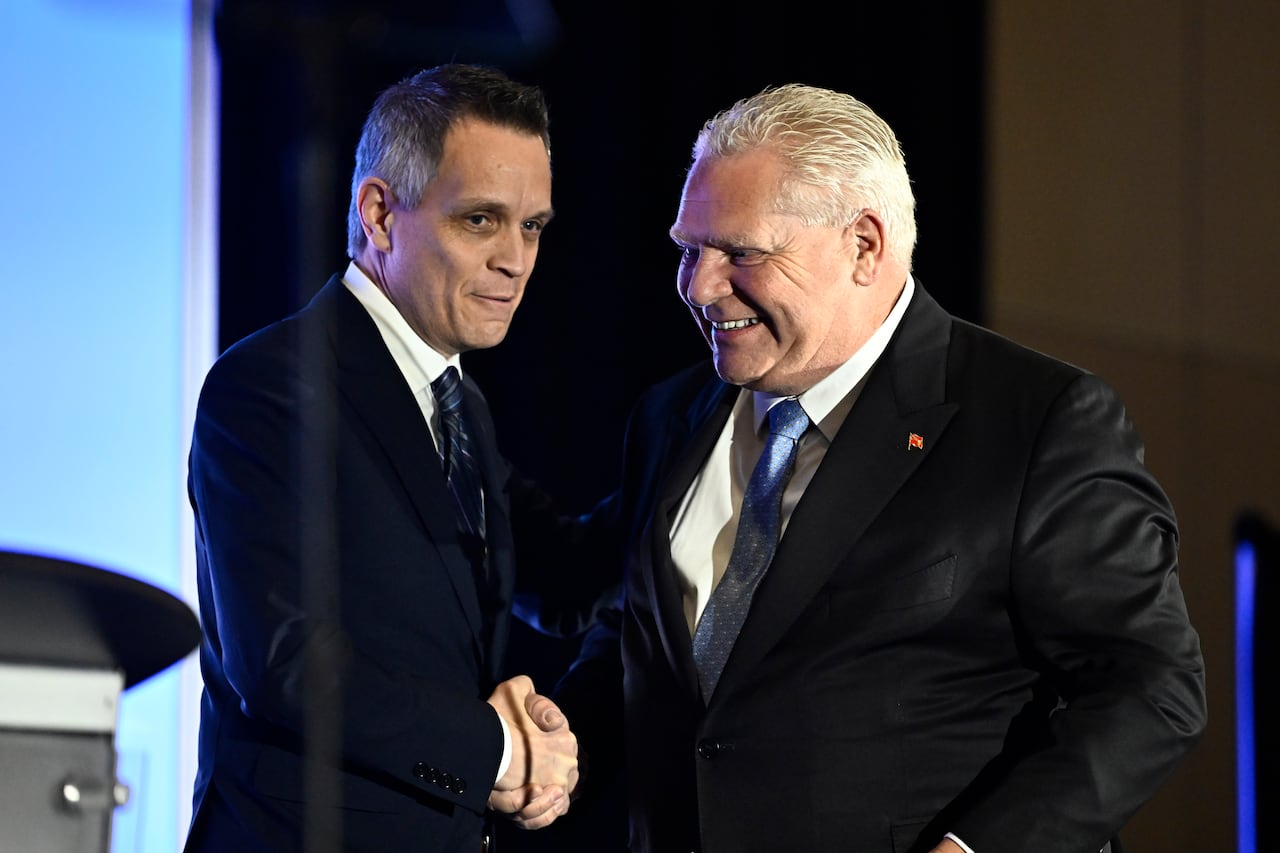 A premier and mayor shake hands, looking happy.