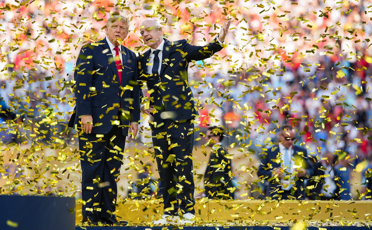 Men stand while confetti falls.