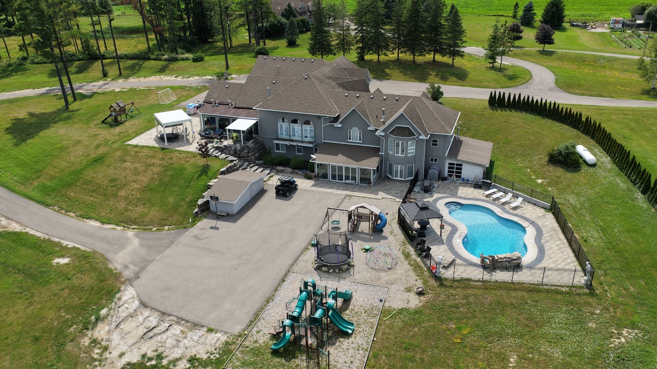 a bird's eye view of a large house with a swimming pool and many outdoor kids toys