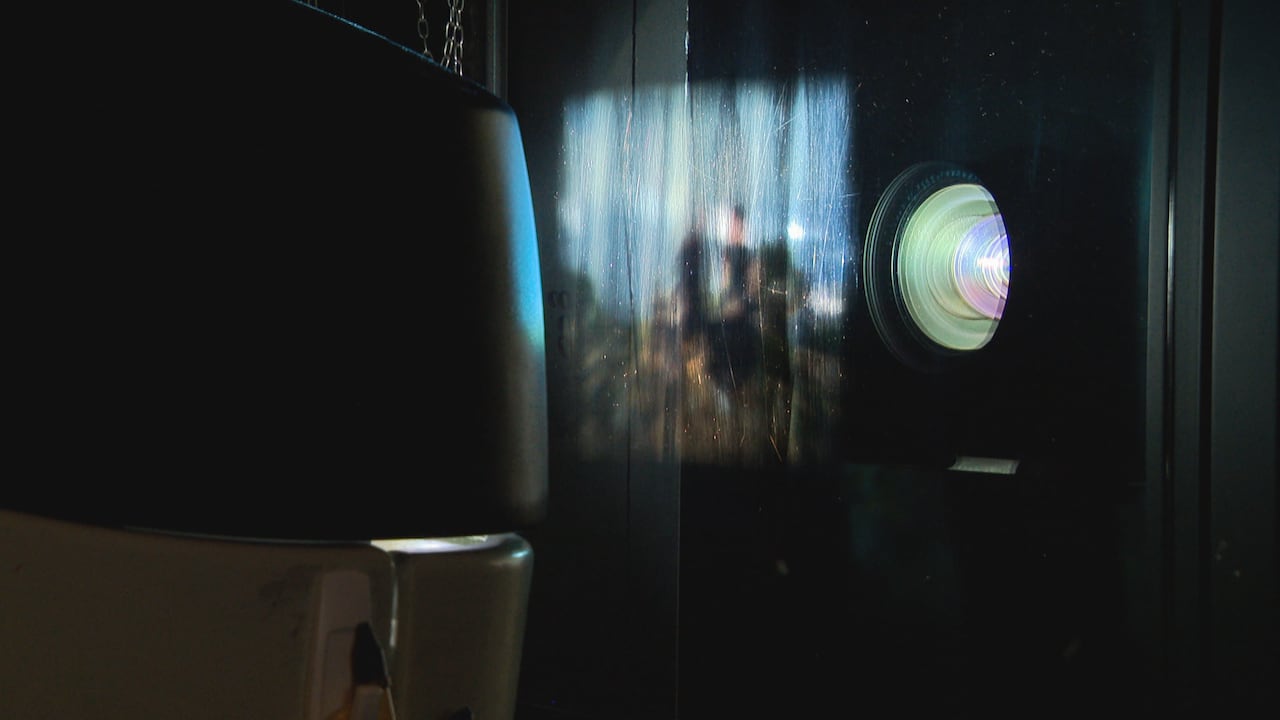 A blurry image is visible between a light source and a screen.