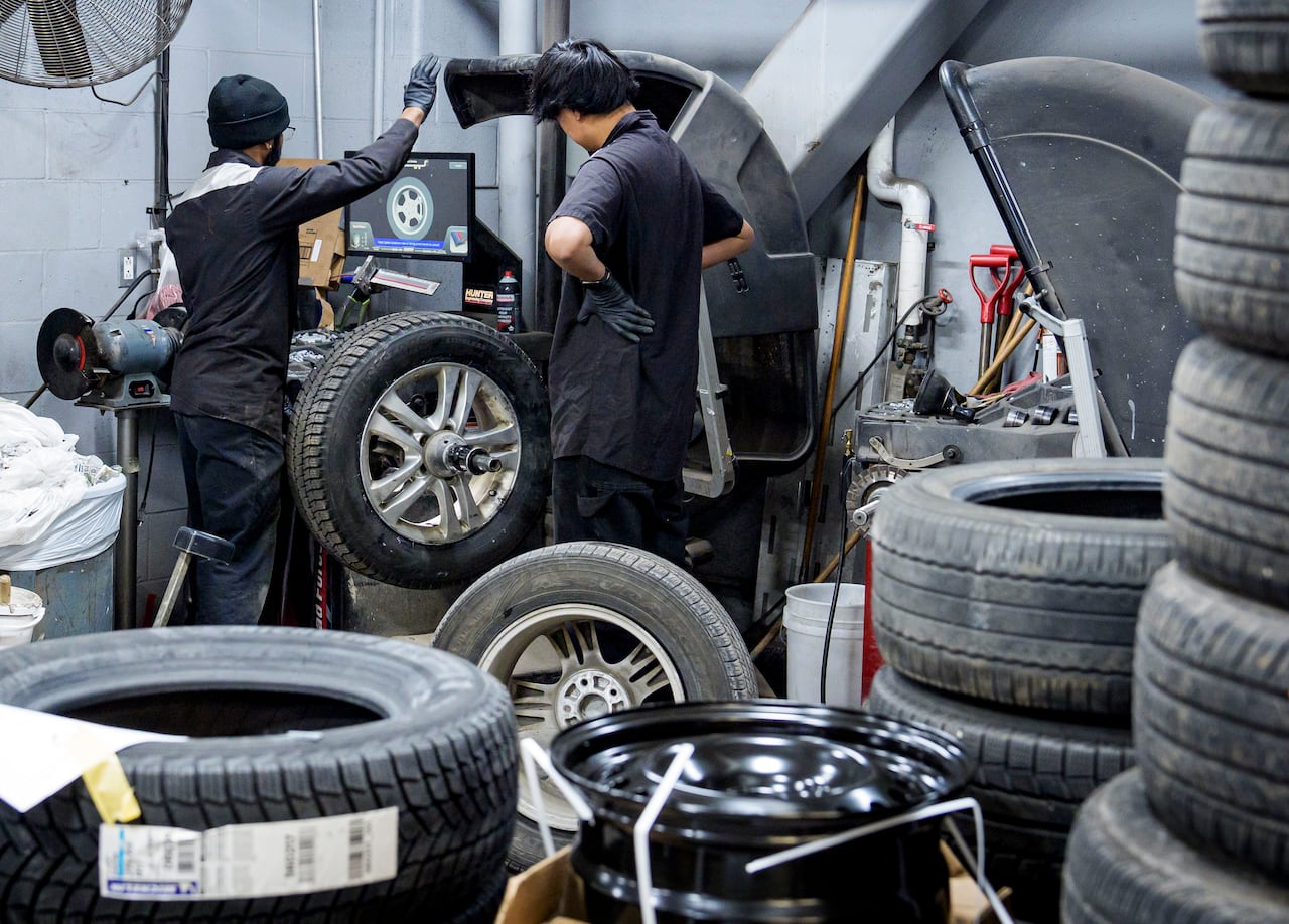 A mechanic readies winter tires at a Toronto-area garage on Nov. 11, 2025 — a day after an early season snowstorm swept Southern Ontario.