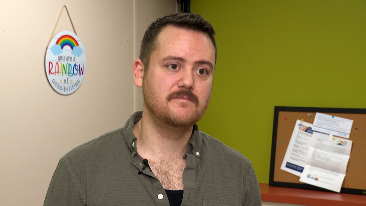 A person wearing a green shirt being interviewed.
