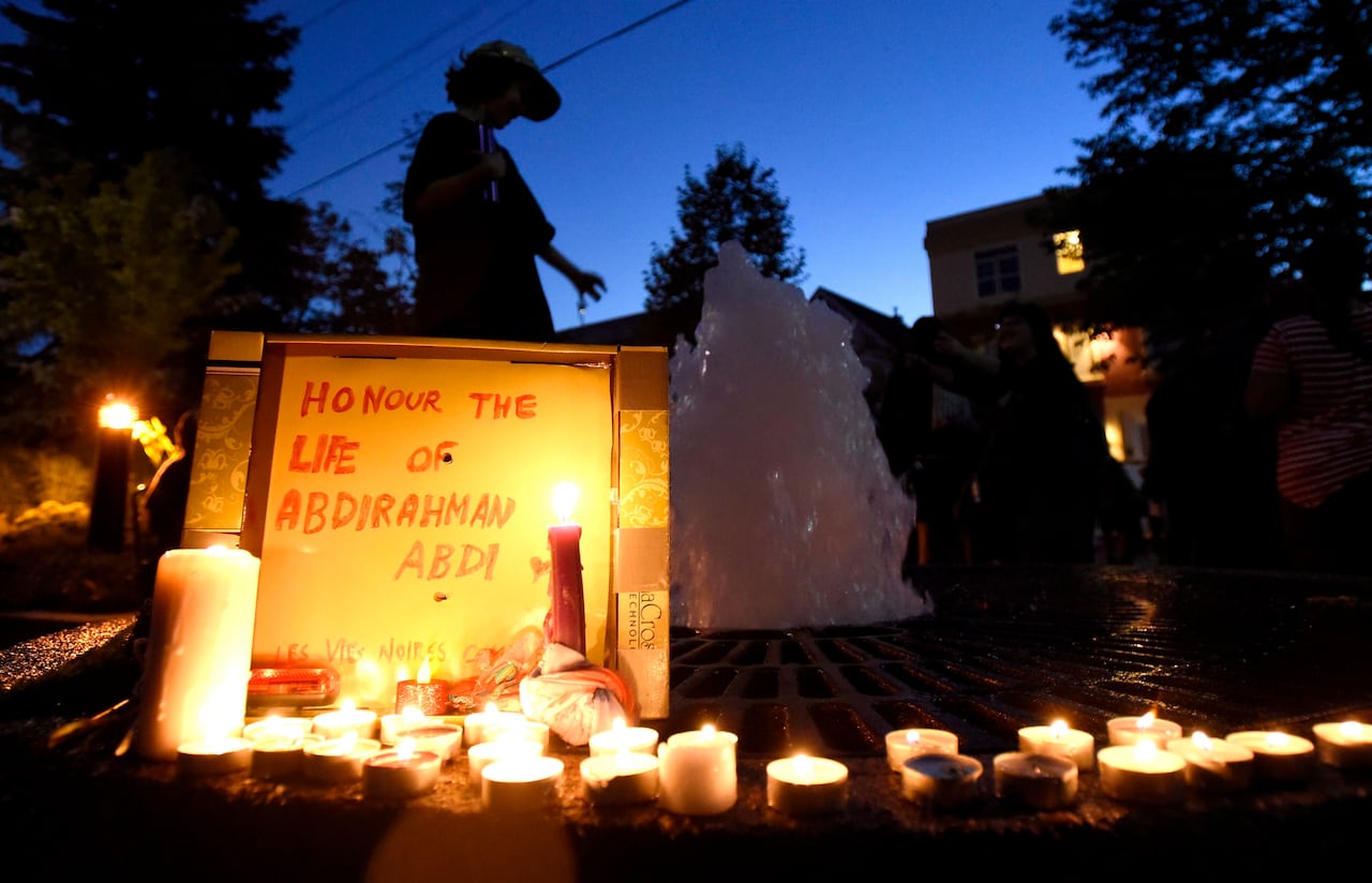 A boy plays in a fountain surrounded by candles lit in a memorial for Abdirahman Abdi, who died after an altercation with Ottawa Police officers Sunday, on Tuesday, July 26, 2016 in Ottawa.
