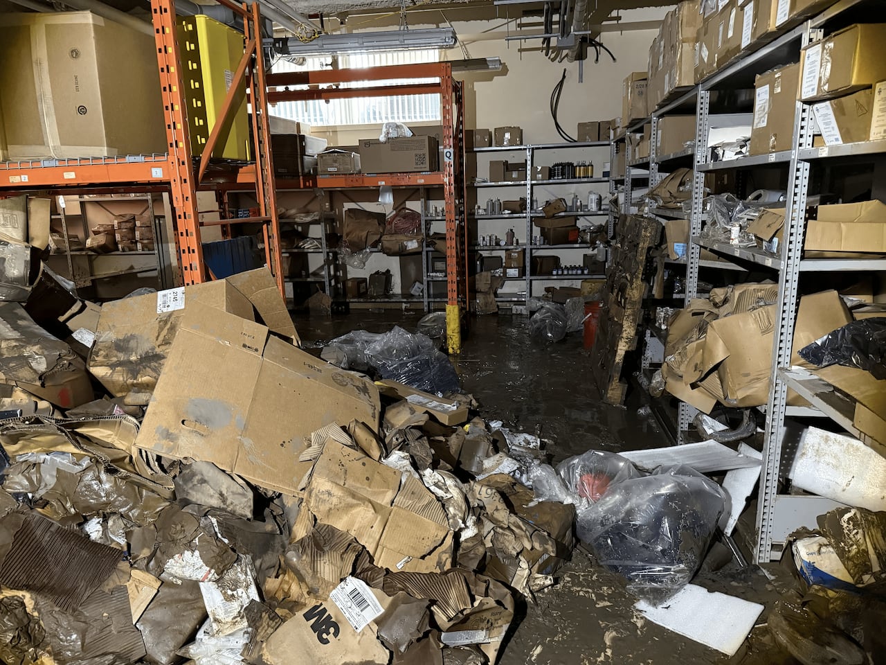 A room with supplies washed out onto the muddy floor.