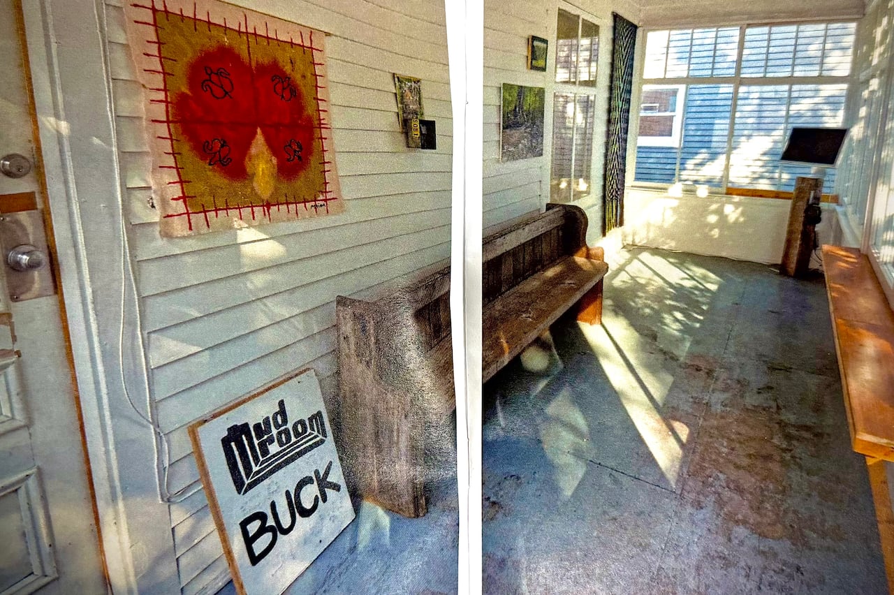 The interior of the Mudroom Gallery showing artwork on white walls with natural light streaming through the windows of the converted front porch.