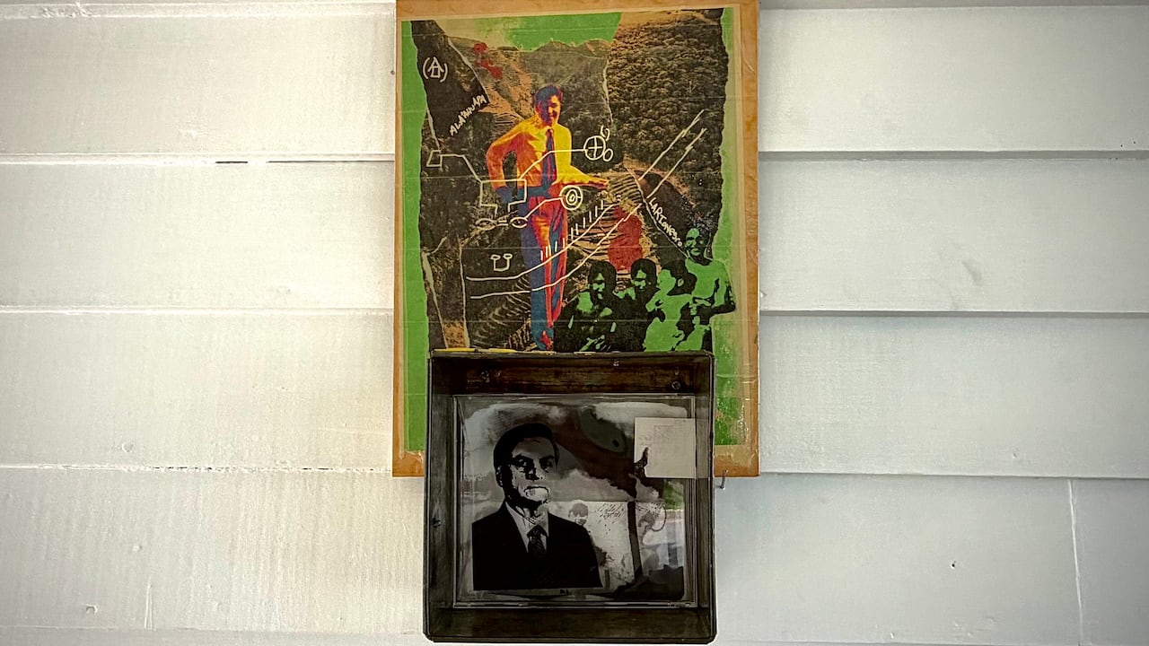 A layered mixed media artwork displayed inside a box structure on the wall of the Mudroom Gallery in Fredericton.