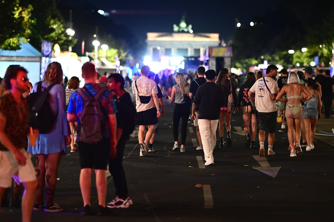 People walk on a street at night.