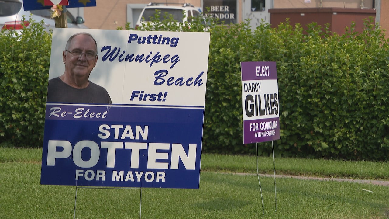Two election signs are in the ground in summer.