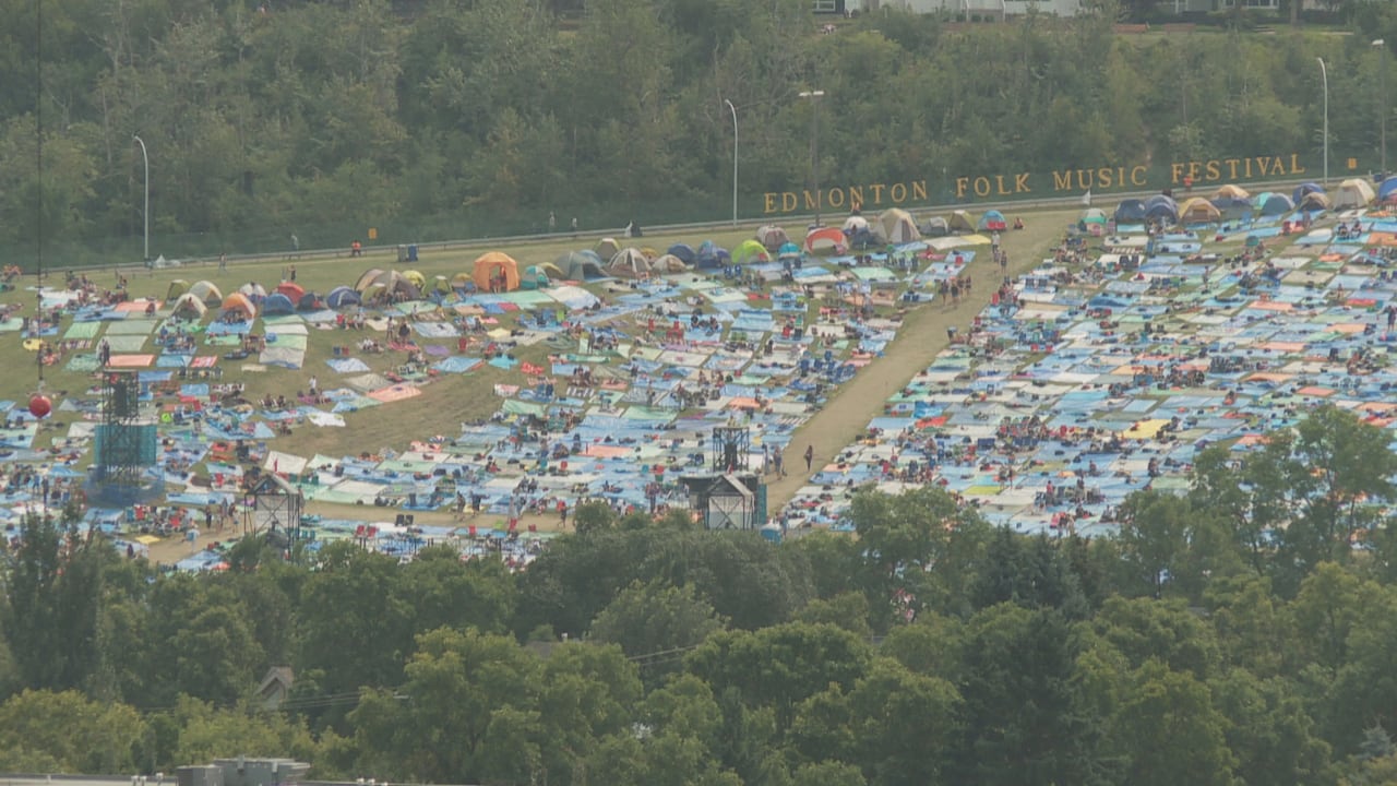 Tarps and tents are seen on a section of grass.
