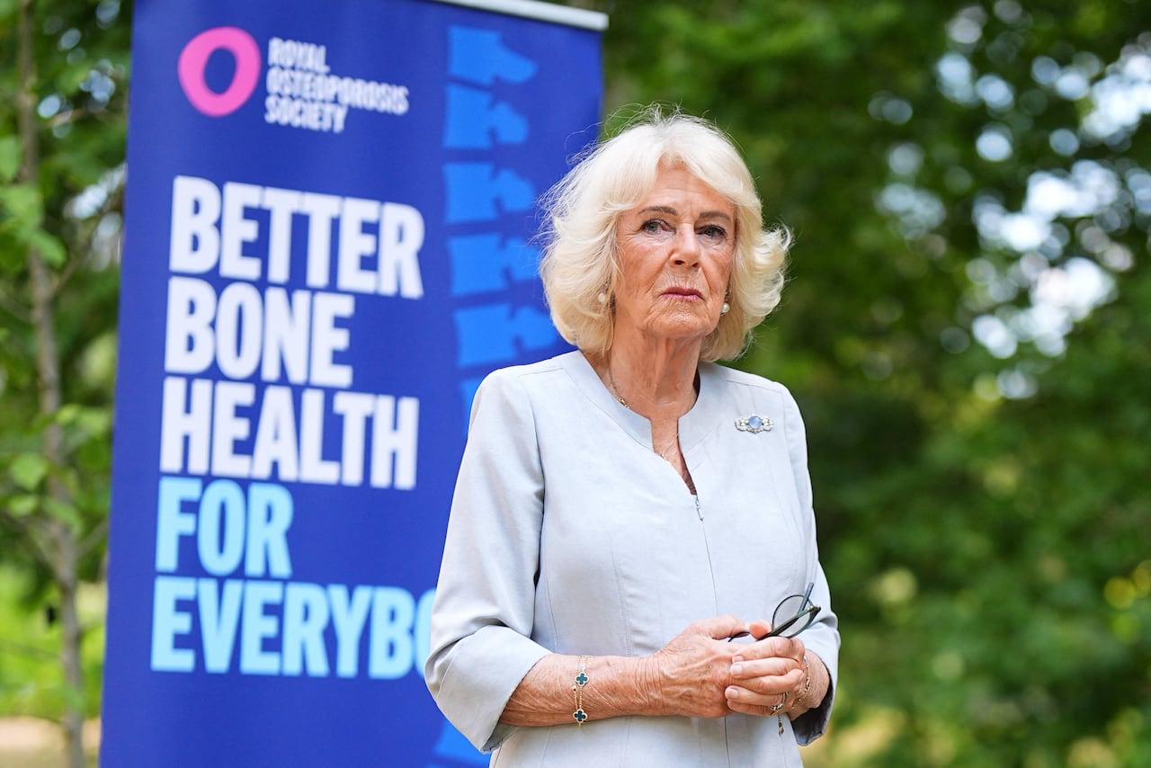 A person stands outside in front of a sign that says "Better Bone Health For Everybody."