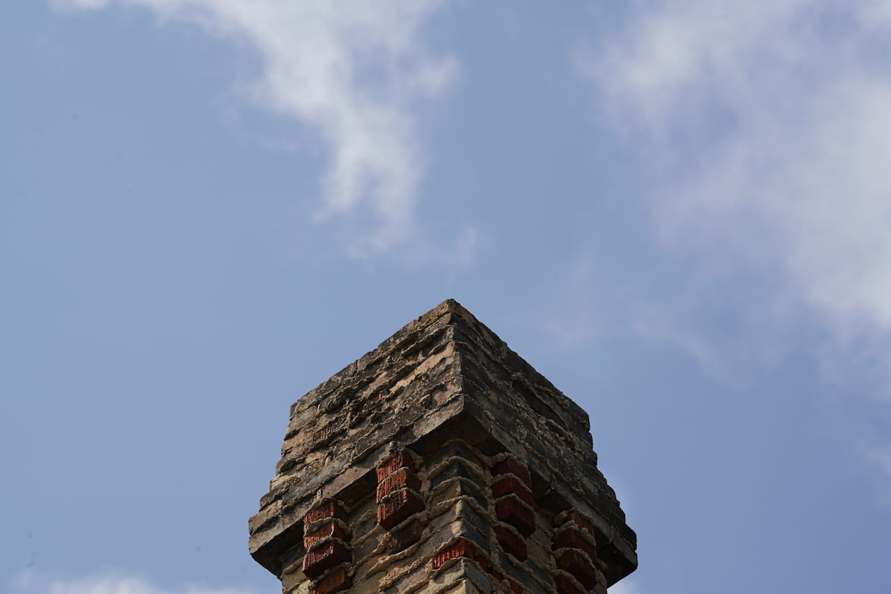 A chimney is seen set against a blue sky.