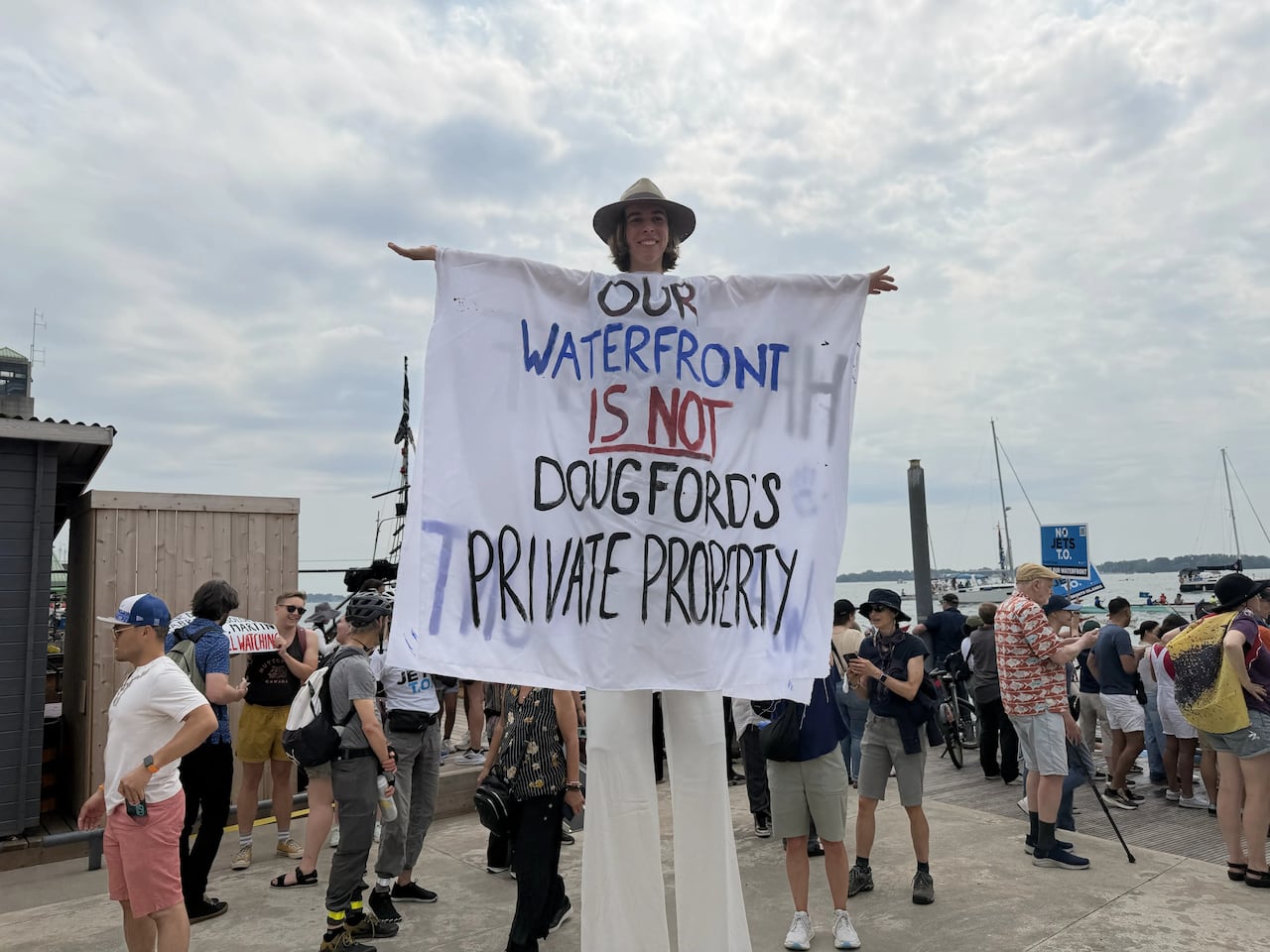 Person on stilts wearing white cloth with words written on it