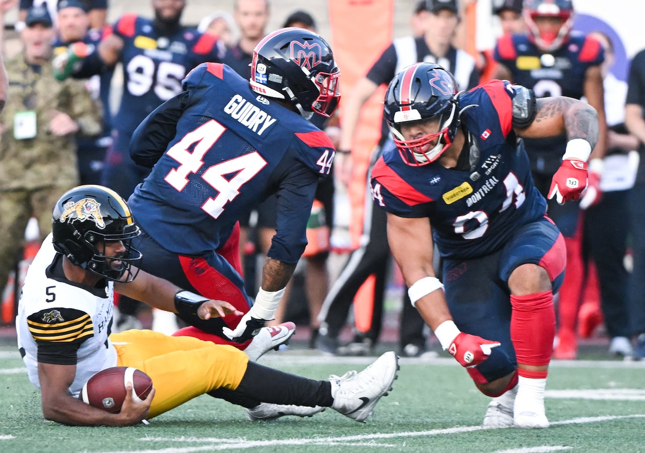 Hamilton Tiger-Cats quarterback Tre Ford (5) is sacked by Montreal Alouettes' Mustafa Johnson (94) during first half CFL football action in Montreal, on Sunday, July 26, 2026.