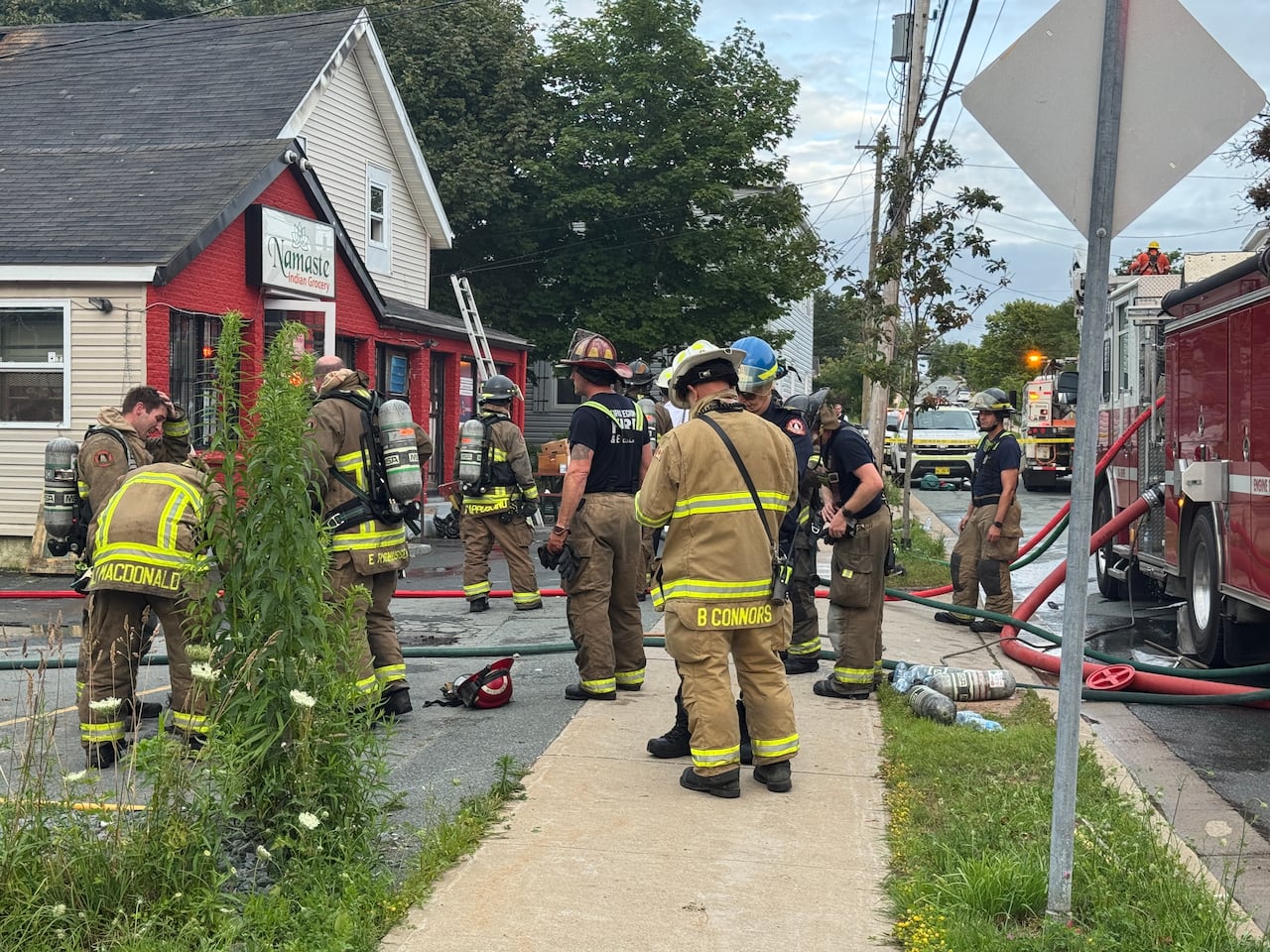 Firefighters stand near a grocery store.